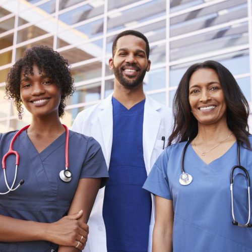 Three healthcare colleagues standing outside modern hospital